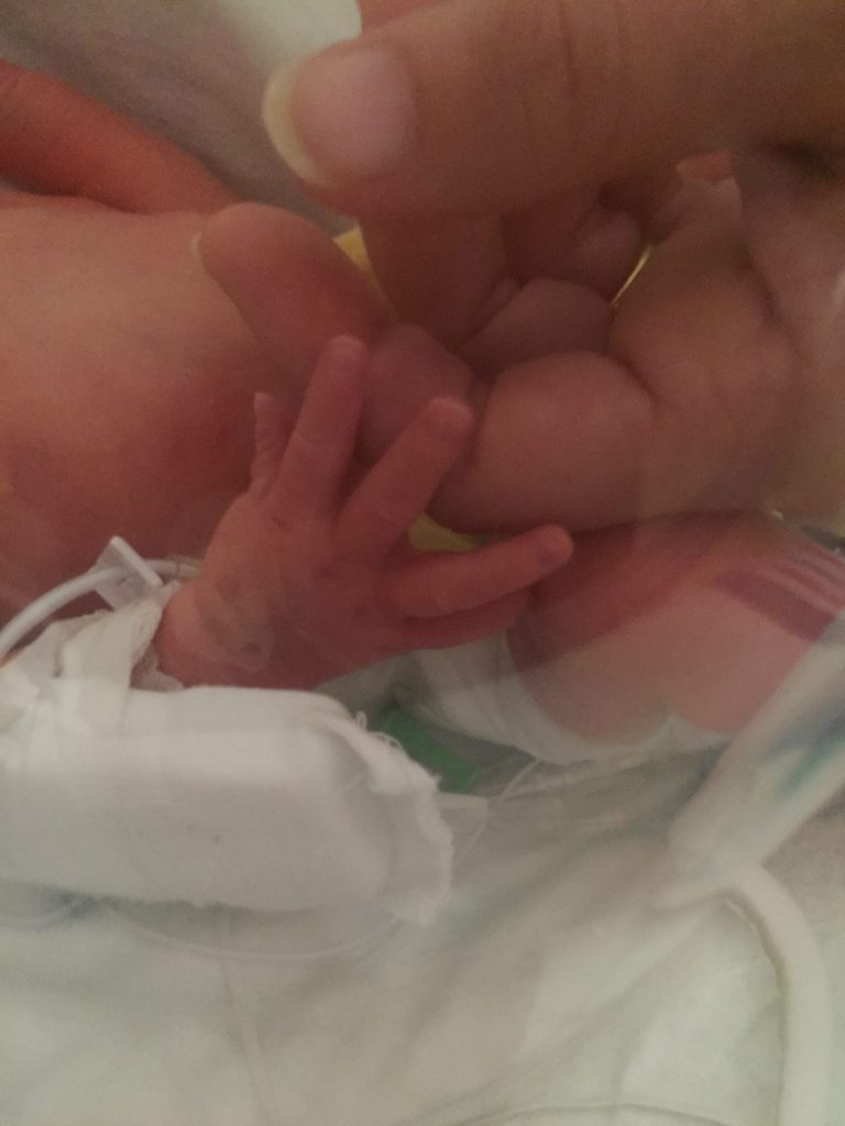 Jay and mom fingers NICU grad mom and sons first touch isolette life is hard when you can only reach into a box and touch your little one. Momma holding hands with her preemie for the first time