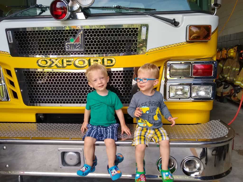 Twin brothers sitting on a Volunteer Fire Department Fire engine.