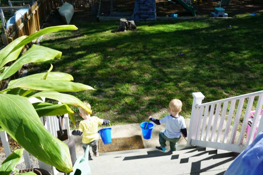 Twin brothers with buckets going down stairs