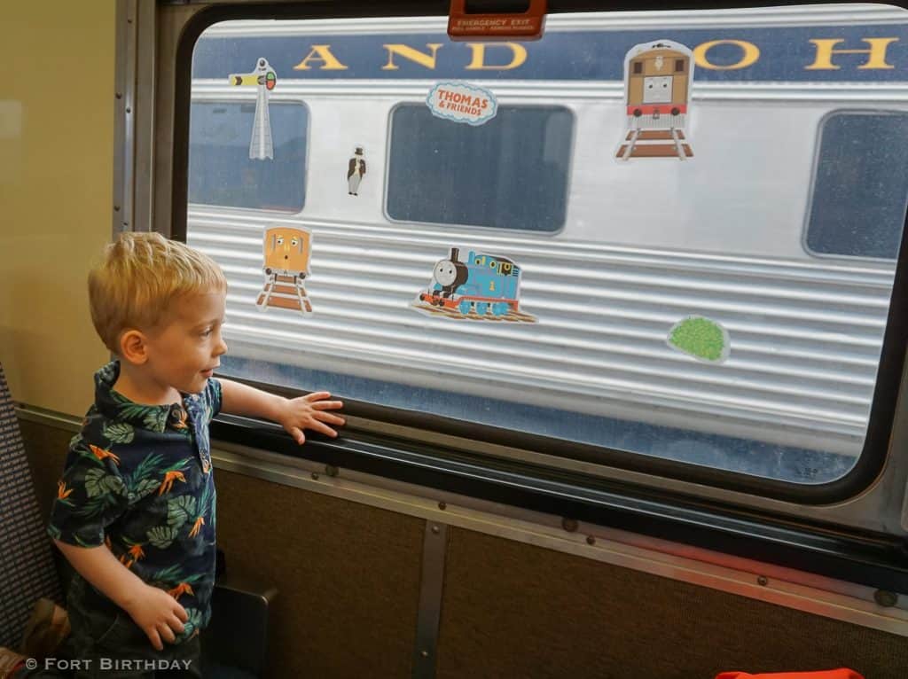 Toddler excitedly looking out a train window at A Day out with thomas